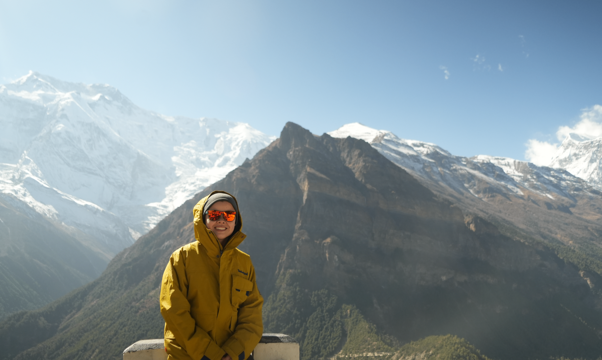 Mandy standing by a railing overlooking a green mountain valley